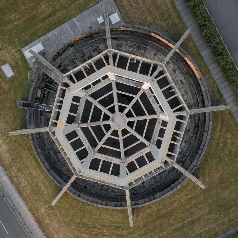 Entdecken Sie die imposante Architektur von Phoenix West in Dortmund - eine ehemalige Industrieanlage mit charakteristischer achteckiger Struktur, markanten Betonpfeilern und harmonischer Einbettung in die urbane Grünlandschaft. Ein beeindruckendes Zeugnis der industriellen Transformation.
