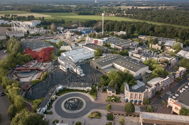 Luftaufnahme des Movie Park Germany mit Achterbahnen, Themenbereichen und umliegender Natur. Erleben Sie spannende Attraktionen und Achterbahnen im Movie Park Germany, dem ultimativen Freizeitpark für die ganze Familie. Entdecken Sie Movie Park Germany, Freizeitpark, Achterbahnen und vieles mehr!
