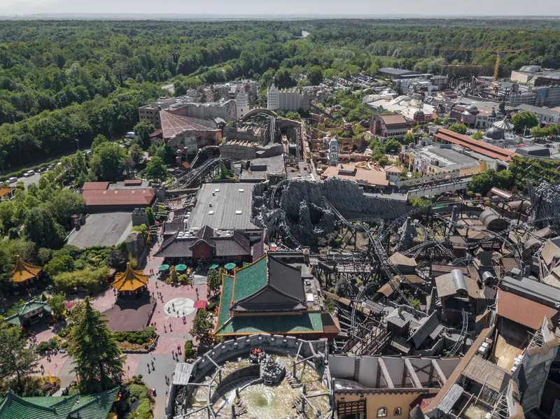 Atemberaubende Luftaufnahme des Phantasialands in Brühl: Entdecken Sie die einzigartige Mischung aus asiatischer und europäischer Architektur, spektakuläre Achterbahnen und weitläufige Themenbereiche inmitten einer grünen Parklandschaft. Der perfekte Einblick in einen der führenden Freizeitparks Europas.
